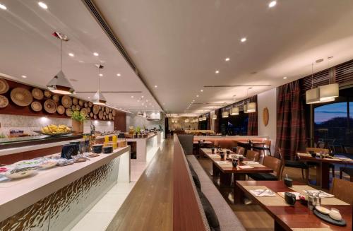 a restaurant with tables and chairs and a bar at Radisson Blu Hotel, Nairobi Upper Hill in Nairobi