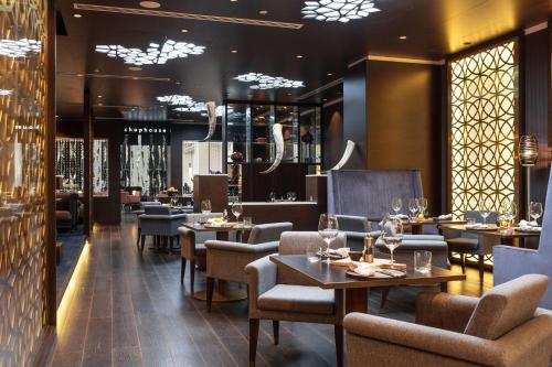 a restaurant with tables and chairs and windows at Radisson Blu Hotel, Nairobi Upper Hill in Nairobi