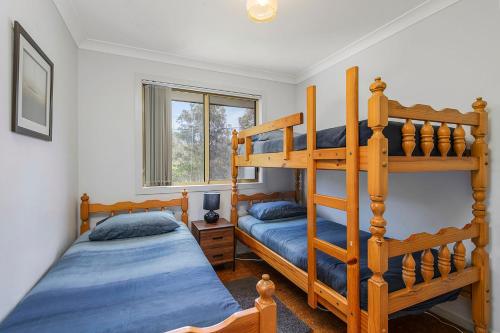 a bedroom with two bunk beds and a window at Bellhaven 1, 17 Willow Street in Crescent Head