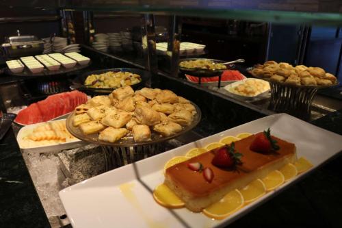 a buffet of food with a piece of cake and strawberries at Radisson Blu Hotel, Yanbu in Yanbu