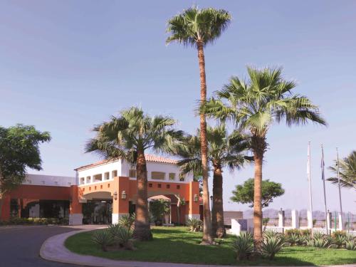 a building with palm trees in front of it at Radisson Blu Hotel, Yanbu in Yanbu
