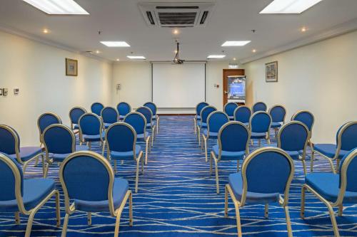 a conference room with blue chairs and a whiteboard at Radisson Blu Hotel, Yanbu in Yanbu