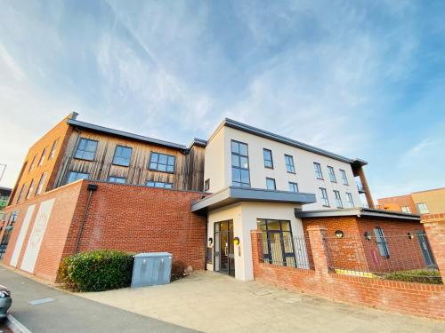 a large brick building with windows on a street at Oakgrove Apartment - 2 Bedroom with Terrance and private parking in Milton Keynes