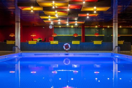 a large swimming pool in a room with a bar at Radisson Blu, Basel in Basel