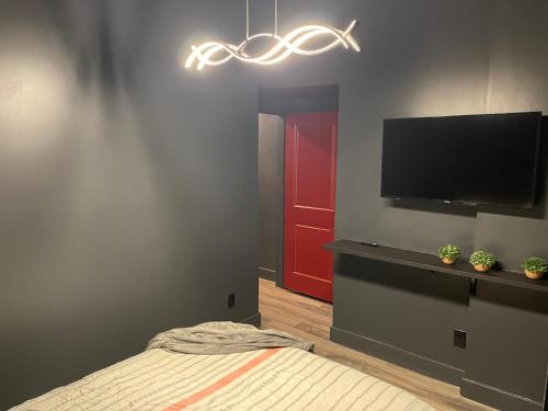 a bedroom with a bed and a flat screen tv at City Loft Escape with River Views! By Hollyhock in Louisville