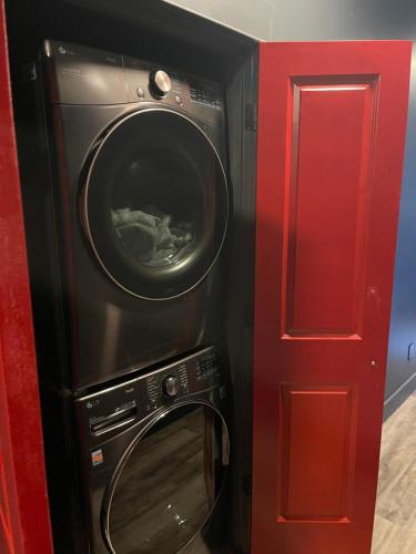 a washer and dryer next to a red door at City Loft Escape with River Views! By Hollyhock in Louisville