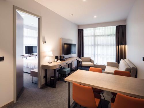 a hotel room with a desk and a room at Executive Residency by Best Western Amsterdam Airport in Hoofddorp