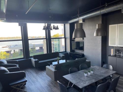 a living room with couches and a table and chairs at City Loft Escape with River Views! By Hollyhock in Louisville