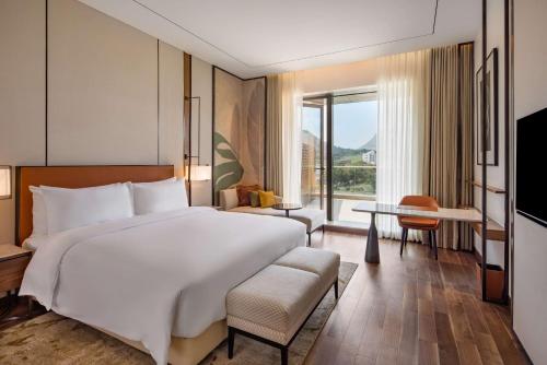 a bedroom with a large bed and a large window at Radisson Blu Hotel & Spa, Nashik in Nashik