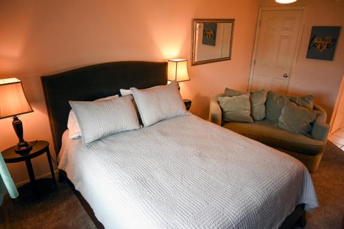 a bedroom with a large white bed and a couch at The Adamina in Fairbanks