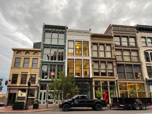 a black truck parked in front of a building at City Loft Escape with River Views! By Hollyhock in Louisville