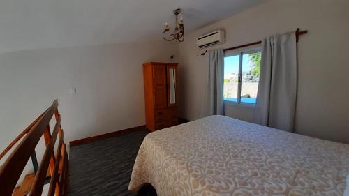 a bedroom with a bed and a sliding glass door at Navarro Departamentos Temporarios in Navarro