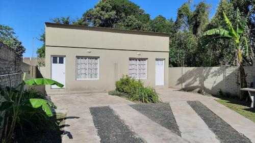 a white building with two doors on it at Navarro Departamentos Temporarios in Navarro