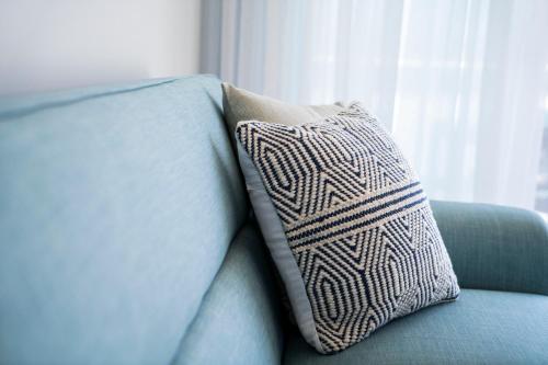 a pillow sitting on the back of a blue couch at Harbour Cove in Airlie Beach
