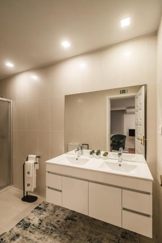 a bathroom with two sinks and a large mirror at Casa de Âncora in Vila Praia de Âncora