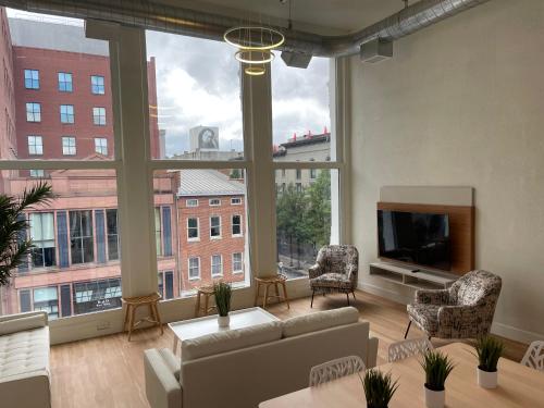 a large living room with a large window at Lou-City Penthouse Suite! Savor Life with Hollyhock in Louisville
