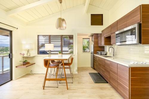 una cocina con armarios de madera y una mesa con sillas. en Pali Kai Cottage 17 A, Ocean Bluff, Nawiliwili, en Lihue