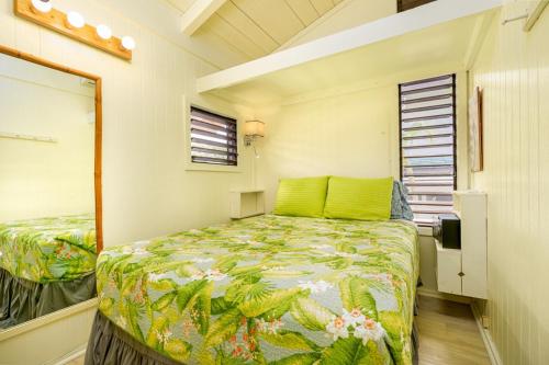 Un dormitorio con una cama con sábanas verdes y una ventana en Pali Kai Cottage 17 A, Ocean Bluff, Nawiliwili, en Lihue