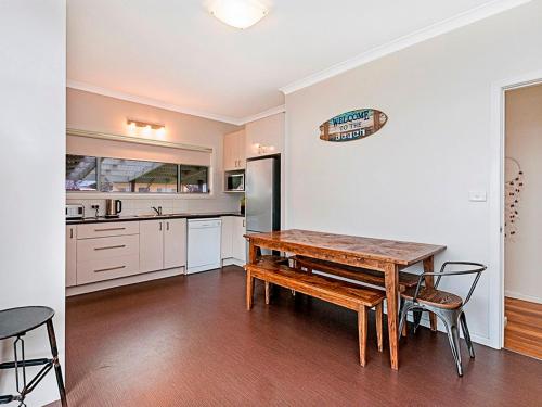 a kitchen with a wooden table and chairs in it at Southern Tides in Port Fairy