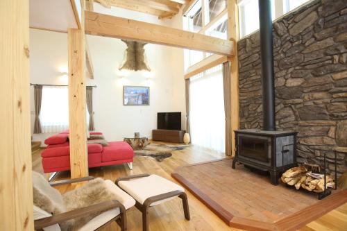 a living room with a stone wall and a stove at Villa Bavaria by Hakuba White Fox Company in Hakuba