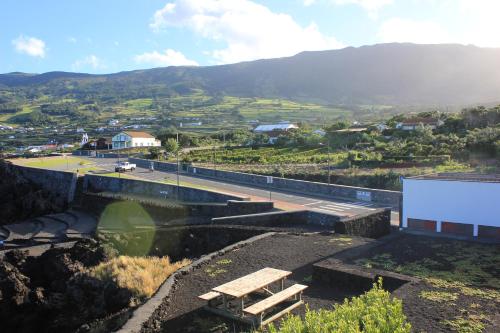 a building with a picnic table on top of a hill at Adega Do Mirante in São Roque do Pico