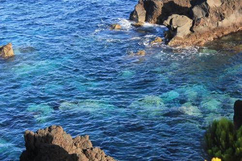 a body of water with rocks and the ocean at Adega Do Mirante in São Roque do Pico