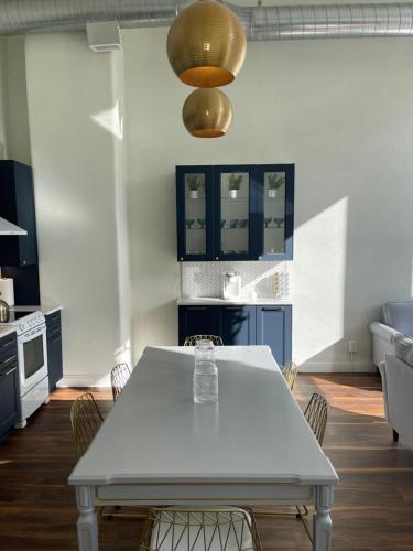 a kitchen with a white table and blue cabinets at Gold Suite by Hollyhock- Executive-Level Living in Louisville