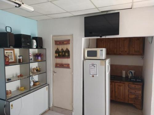 a kitchen with a refrigerator and a microwave at Departamentos Fuentes in Cipolletti