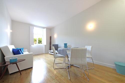 a living room with a table and white chairs at Oporto River and Ribeira Views in Vila Nova de Gaia