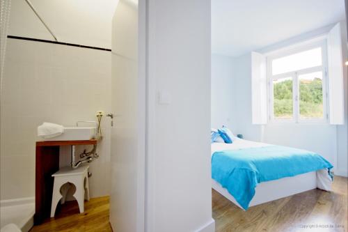a white bedroom with a bed and a window at Oporto River and Ribeira Views in Vila Nova de Gaia