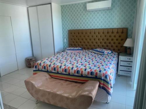 瓜拉久巴的住宿－Casa no condomínio paraíso，一间卧室配有一张床和一张搁脚凳
