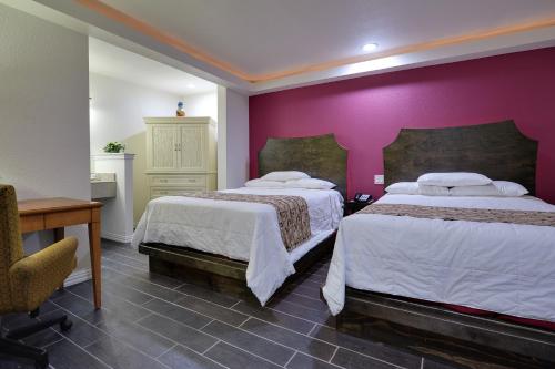 Postel nebo postele na pokoji v ubytování Romantic Inn & Suites