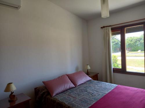 1 dormitorio con cama y ventana en Chalecito hermoso en La Paloma