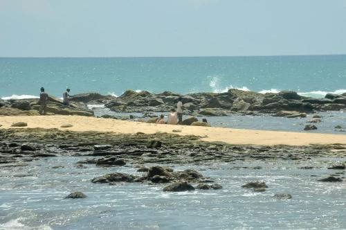a group of people on a beach near the water at Sea Bay Inn Tangalle in Tangalle