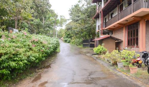 a wet street in front of a house with plants at Sea Bay Inn Tangalle in Tangalle
