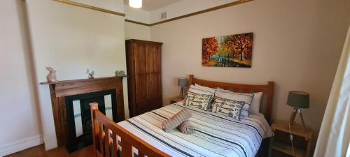- une chambre avec un lit et une peinture murale dans l'établissement Arden on McLachlan, à Orange