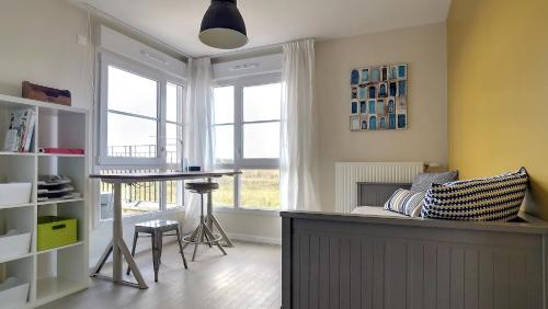 un salon avec une table et une fenêtre dans l'établissement T3 Riviera Apartment Near Disneyland Paris, à Chessy