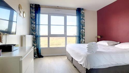 a bedroom with two beds and a large window at T3 Riviera Apartment Near Disneyland Paris in Chessy
