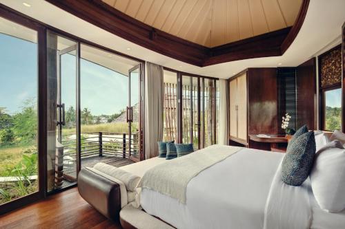 um quarto com uma cama grande e uma varanda em Mango Ubud em Ubud