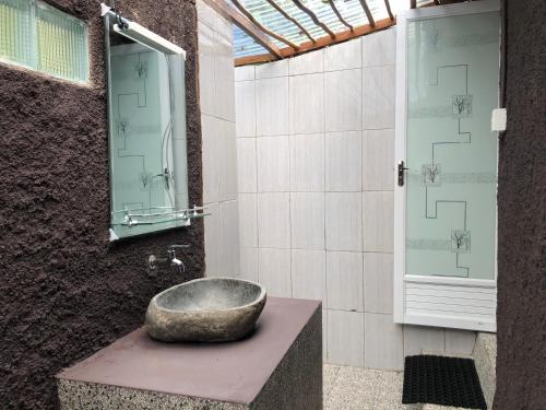 La salle de bains est pourvue d'un lavabo en pierre sur un comptoir. dans l'établissement Sembalun Kita Cottage, à Sembalun Lawang
