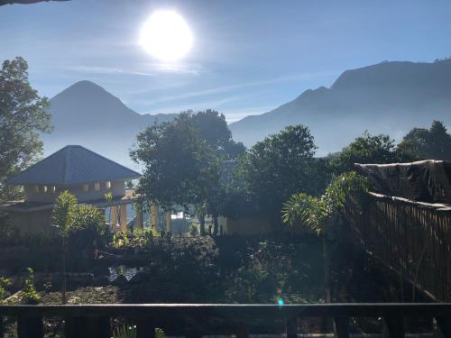 a view of a house with mountains in the background at Sembalun Kita Cottage in Sembalun Lawang