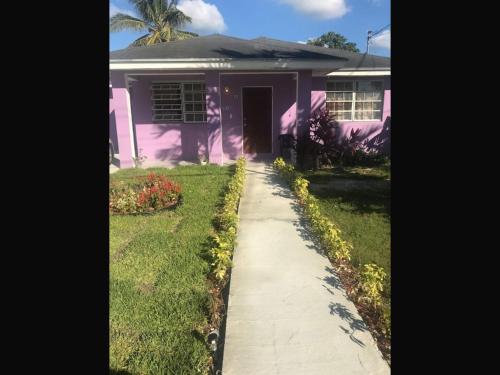 a purple house with a sidewalk in front of it at Room in Apartment - Bahamas petapat suite in Nassau