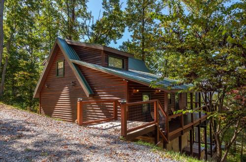 une cabine dans les bois avec une véranda et une terrasse dans l'établissement Bama Bear's Den Cabin, à Sevierville