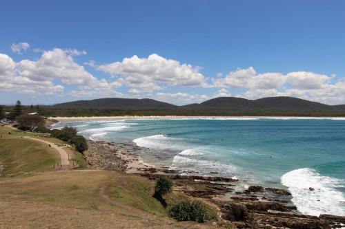 a view of a beach with mountains in the background at Allamanda House, 3 Willow Street in Crescent Head