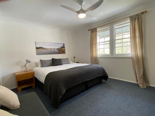 1 dormitorio con 1 cama y ventilador de techo en Allamanda House, 3 Willow Street, en Crescent Head