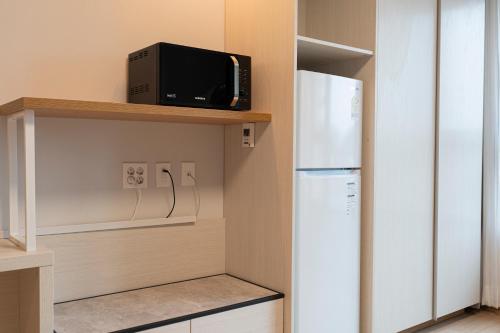a kitchen with a refrigerator and a microwave at Best Western Asan Hotel in Asan