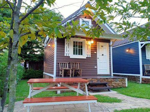 a small house with a picnic table in front of it at The Green Land Farm in Si Khio