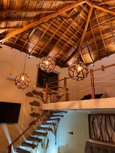 a staircase in a building with chandeliers at Hotel Campestre Palmas del Zamorano in San Gil