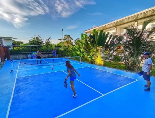 a group of people playing tennis on a tennis court at Beyond Island in Moalboal