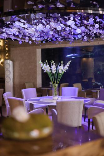 una mesa con sillas moradas y un jarrón de flores en The Sanctuary Resort Pattaya, BW Signature Collection, en Pattaya South